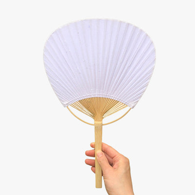 Where to buy Japanese Uchiwa fans near me? A woman holds a round Japanese fan purchased on the kimurakami website.