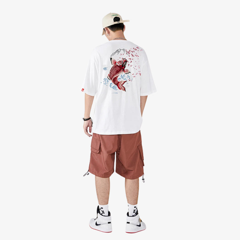 Person wearing a white Japanese Koi shirt with a graphic design and brown shorts on a white background