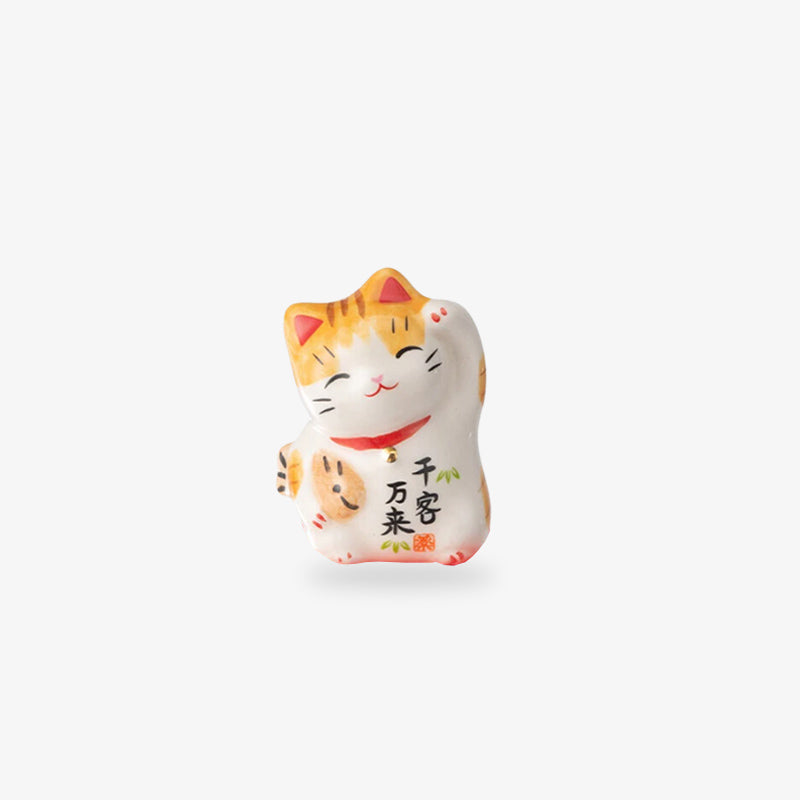 a white japanese luvky cat  raising its left paw to attract luck and wealth