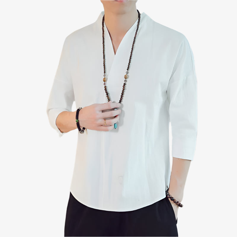 A man dressed with white zen Japanese shirt for a casual outfit. He wears a black pant