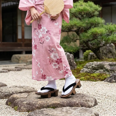 Wooden Japanese Sandals worn with a pink kimono in a Japanese garden