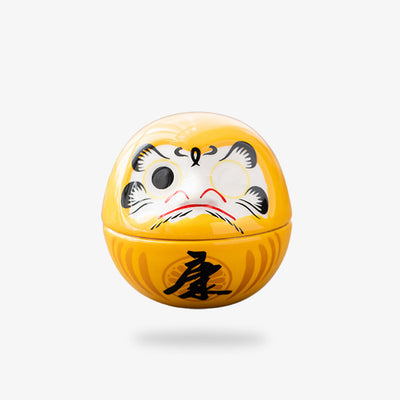 The yellow Daruma money box symbolizes prosperity and financial success, combining the traditional Japanese good luck charm with a practical use as a coin bank.