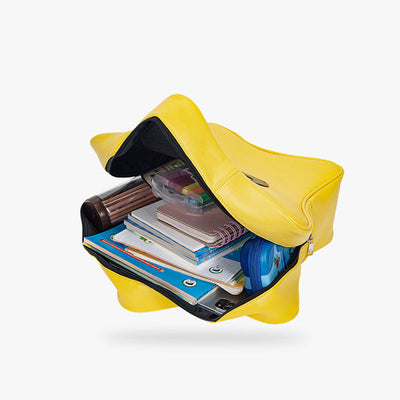 A yellow kawaii backpack. Books are inside the Japanese leather bag.