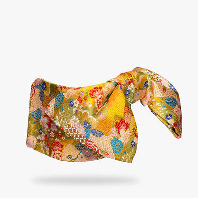 a Japanese yellow obi belt printed with japanese patterns anfd japanese flowers symbols. This geisha belt is made for kimono dresses. The obi knot holds the traditional kimono