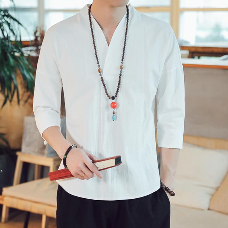 a man dressed with a white yoga t-shirt. He wears a necklace. White shirt made with linen an cotton