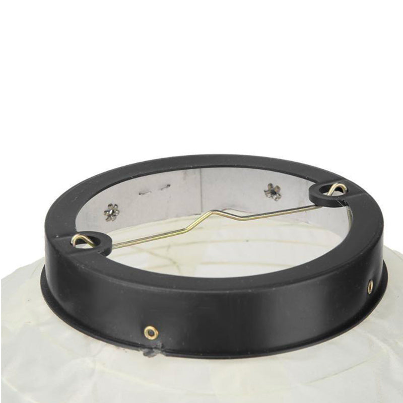 Close-up of a light japanese paper lantern fixture with a black glass cover on a white background