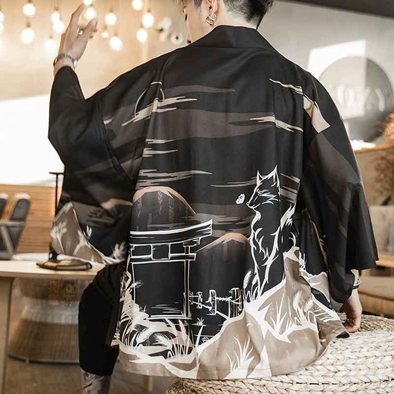 A person wearing a black Kitsune jacket Kimono haori with a white Kitsune (fox demon) design on the back, standing in a room with a modern decor.