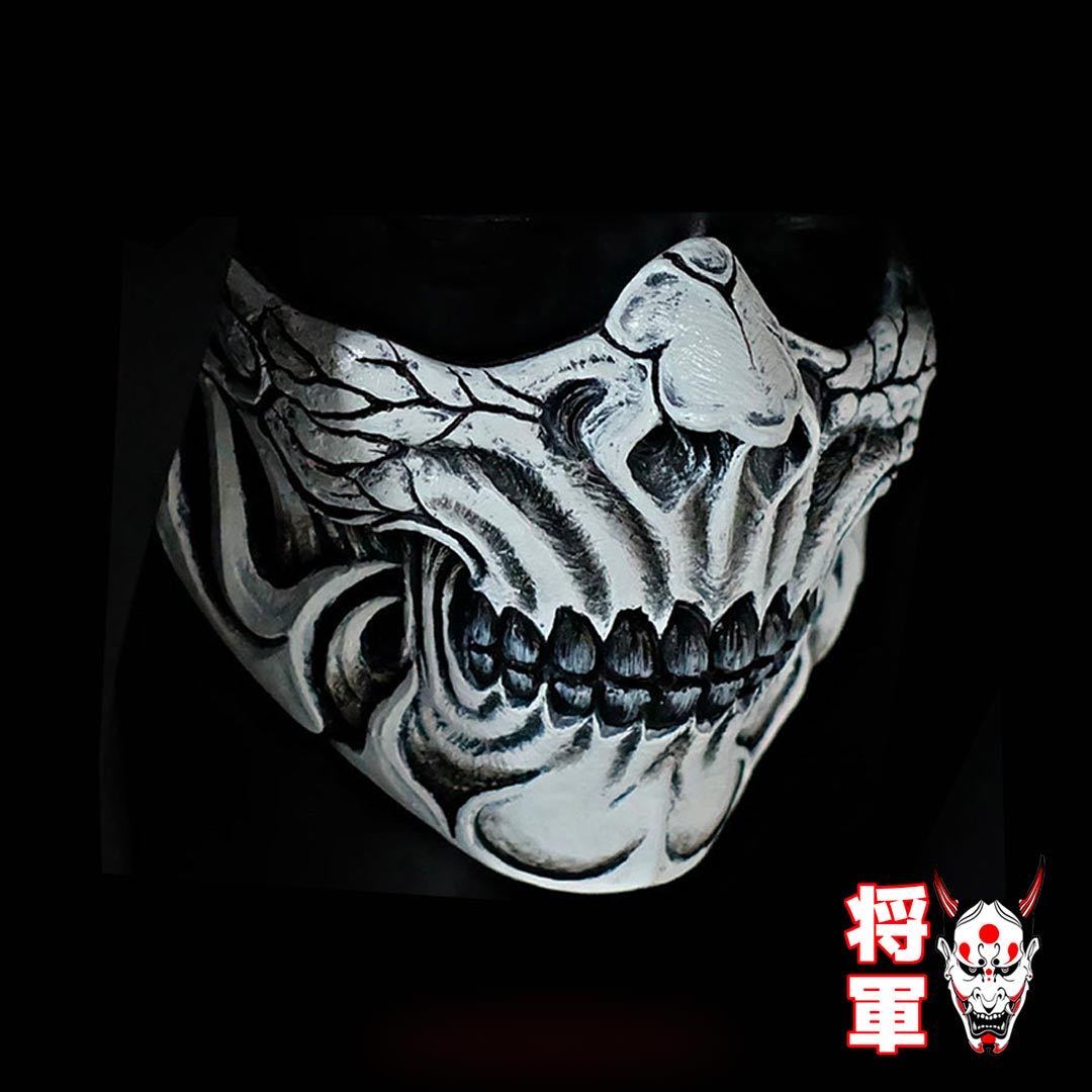 A man wears a Japanese Shinigami Mask. It's a half japanese mask with a demon oni style