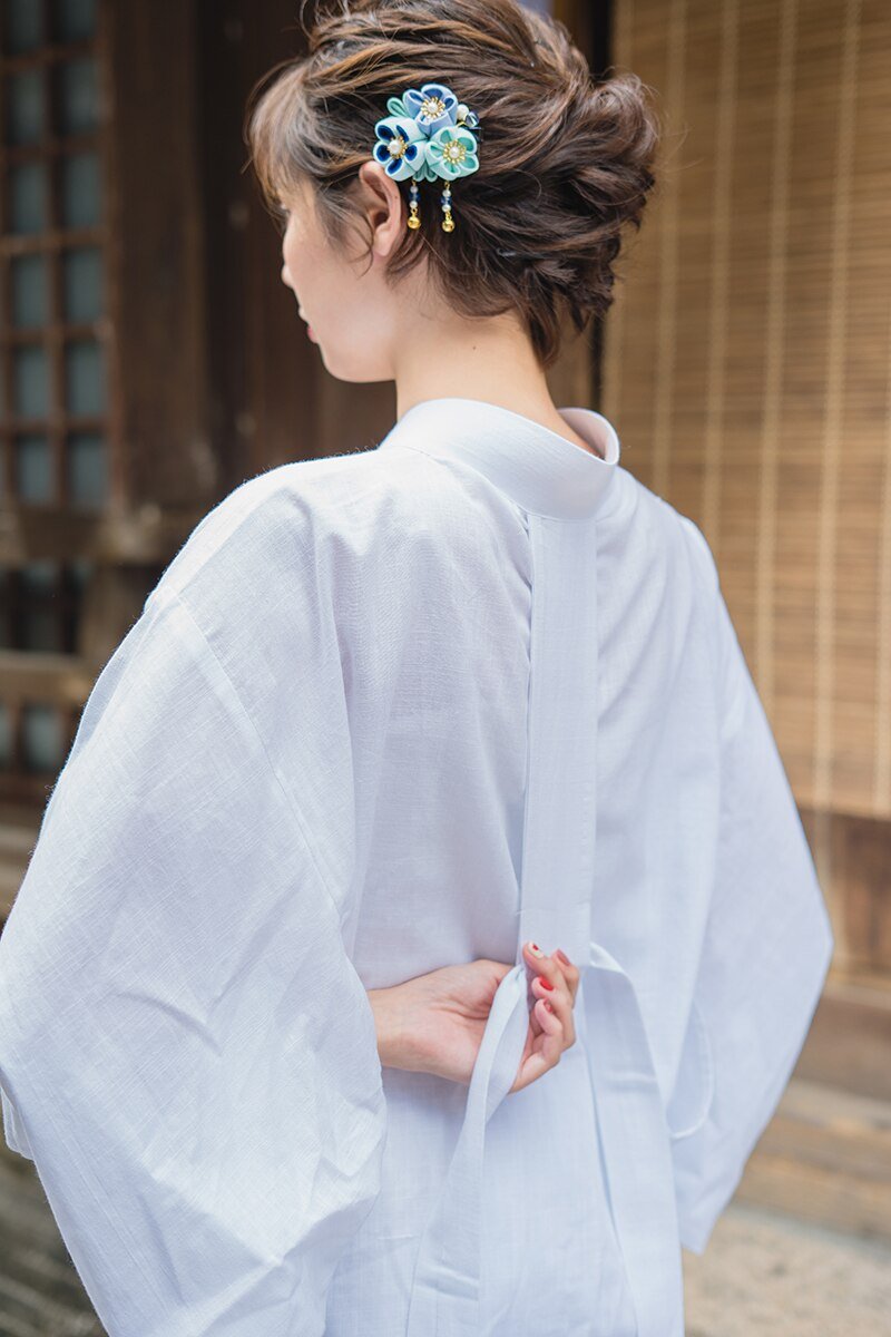 A woman wearing Nagajuban female kimomo with a kanzashi flower in her hair