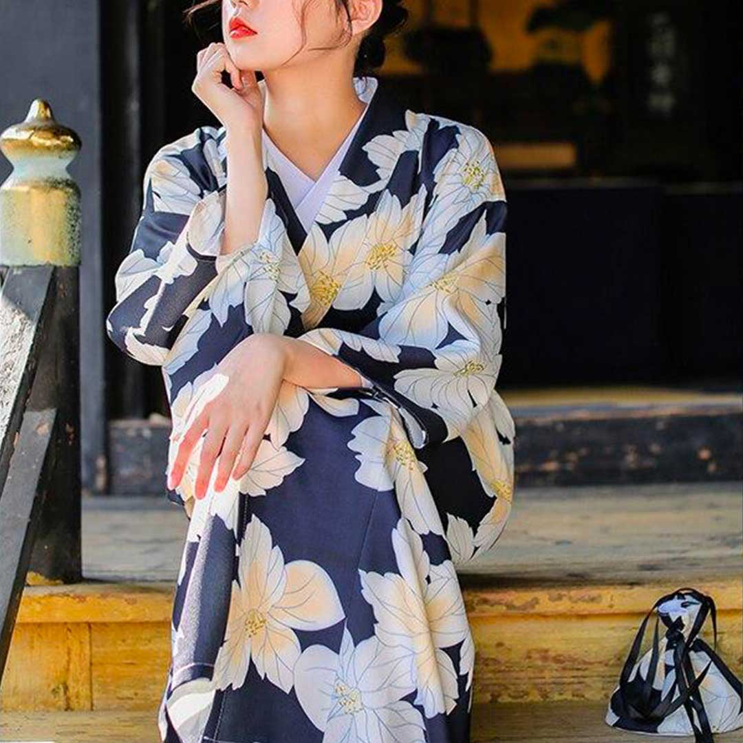 Japanese kimono robe costume with yellow floral prints. The woman is elegantly dressed with a flower kanzashi in her hair