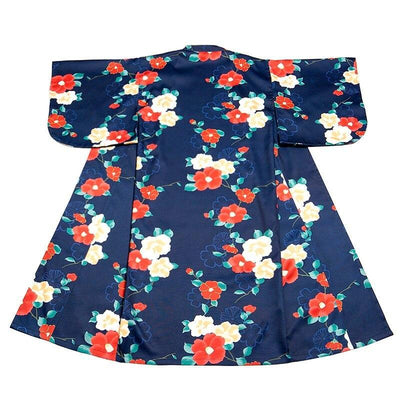 Kimono Japanese robe material with traditional floral symbols, worn by a woman with a Kanzashi in her hair. The long kimono is elegantly closed with an Obi belt