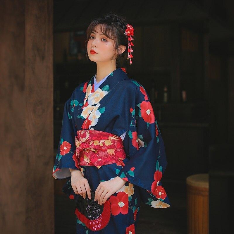 Kimono Japanese robe for women, featuring beautiful flower prints. The long kimono is secured with an Obi belt, and the woman wears a Kanzashi in her hair