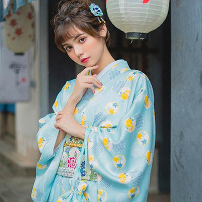 Traditional Japanese dress kimono featuring beautiful floral prints. The woman is standing with her kimono secured by an Obi belt, her hair adorned with a Kanzashi
